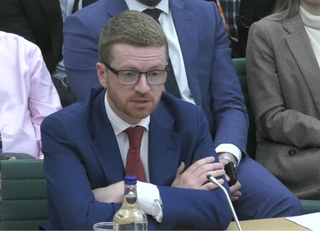 Morgan McSweeney speaks during a parliamentary committee hearing, seated at a desk with a microphone.
