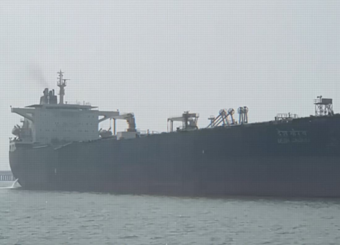 A side-profile view of the large oil tanker MT Desh Gaurav transiting through hazy waters near the Strait of Hormuz during the April 2026 maritime blockade.