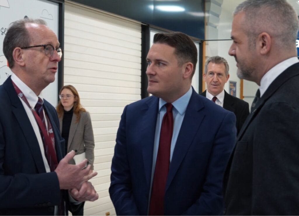 Wes Streeting speaking with officials during a visit to Barnsley, standing indoors in a public building.