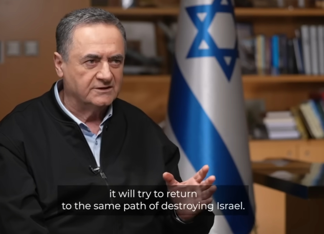 Israeli Defence Minister Israel Katz speaks during a televised interview with an Israeli flag visible in the background.