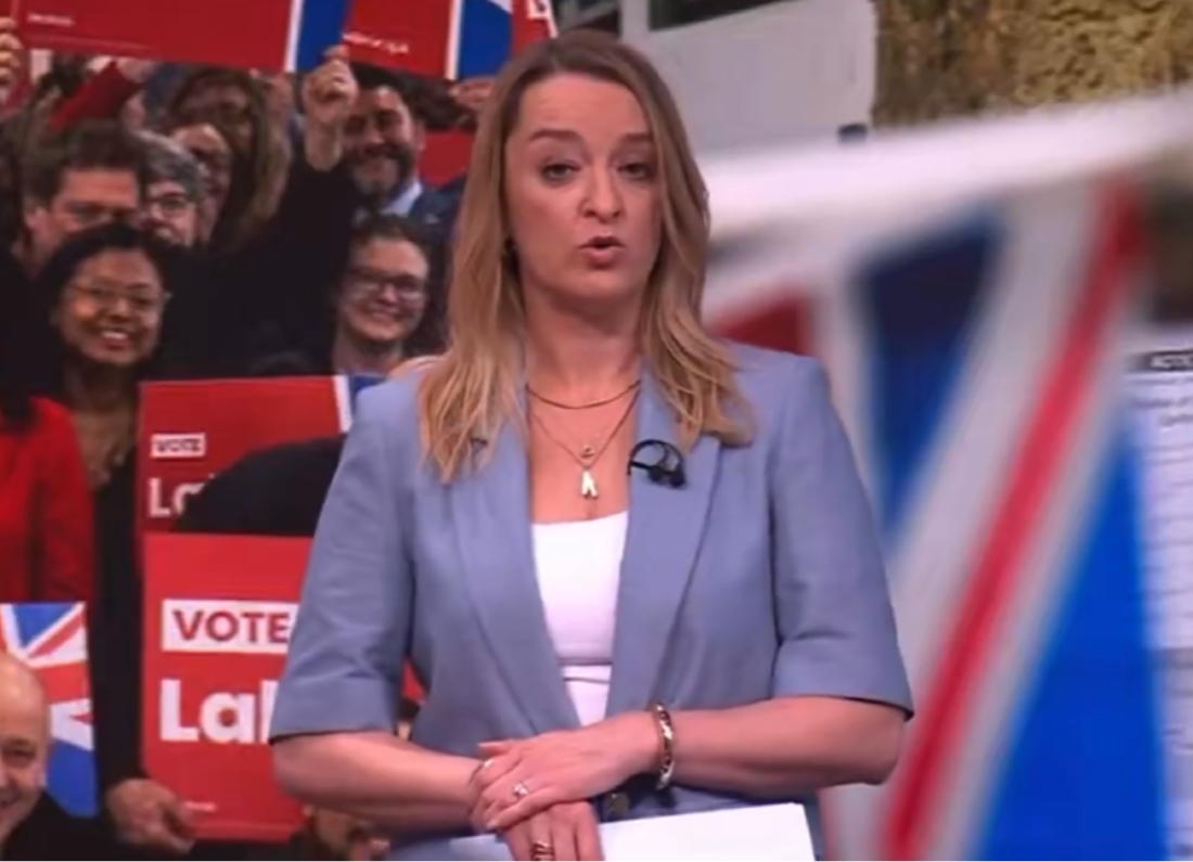 Laura Kuenssberg presenting a political programme in front of a live audience holding Labour signs and Union flags.