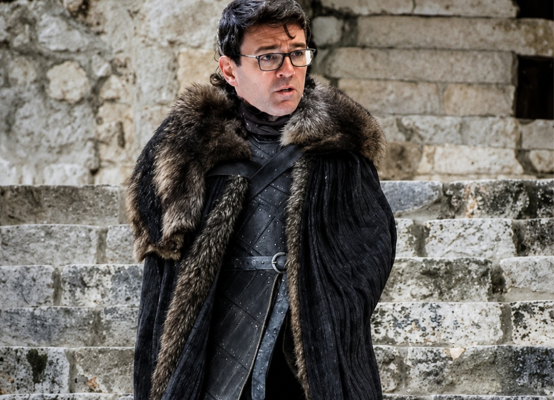 Manchester Mayor Andy Burnham edited into a Game of Thrones-style costume with a large fur cloak while standing on stone steps.