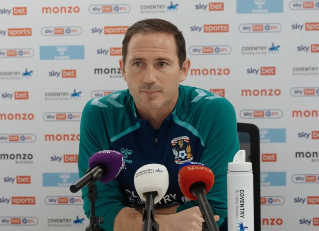 Frank Lampard speaks at a Coventry City press conference with microphones in front of him.