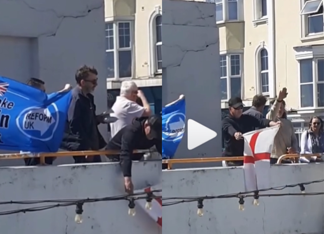 Group of people standing on a balcony holding a Reform UK banner and an England flag during a rally.