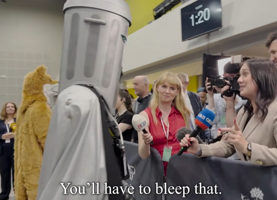 Count Binface being interviewed by GB News at the Makerfield by-election count, with the subtitle “You’ll have to bleep that” on screen.