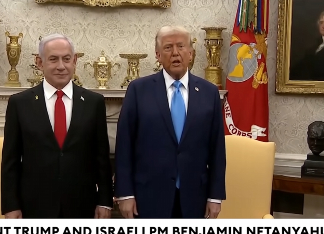 US President Donald Trump and Israeli Prime Minister Benjamin Netanyahu stand together during a meeting at the White House, with official furnishings and military insignia visible in the background.