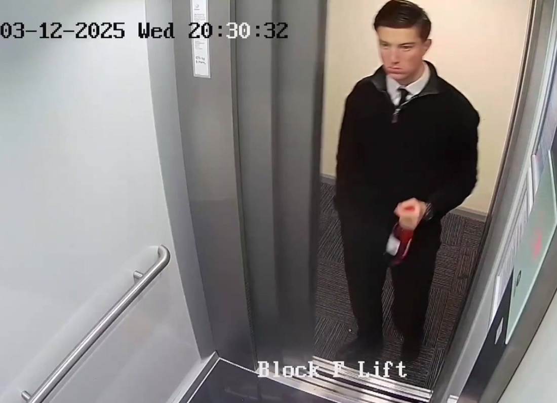 CCTV image showing 18-year-old Henry Nowak entering a lift in a residential building. He is dressed in dark clothing and carrying an item in one hand as he stands inside the lift.