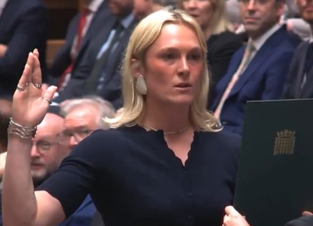SNP MP Lara Bird raising her hand while taking the oath of allegiance in the House of Commons.