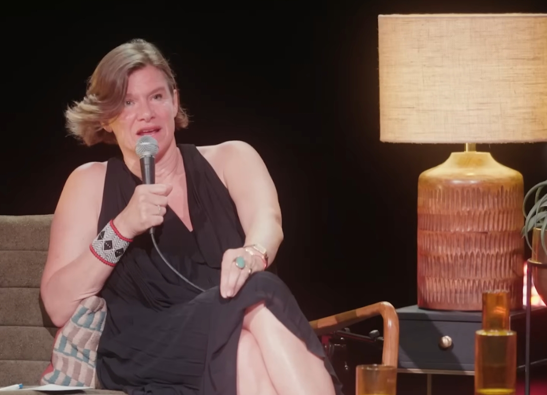 Mariana Mazzucato speaking with a handheld microphone during a live event about The Common Good Economy.
