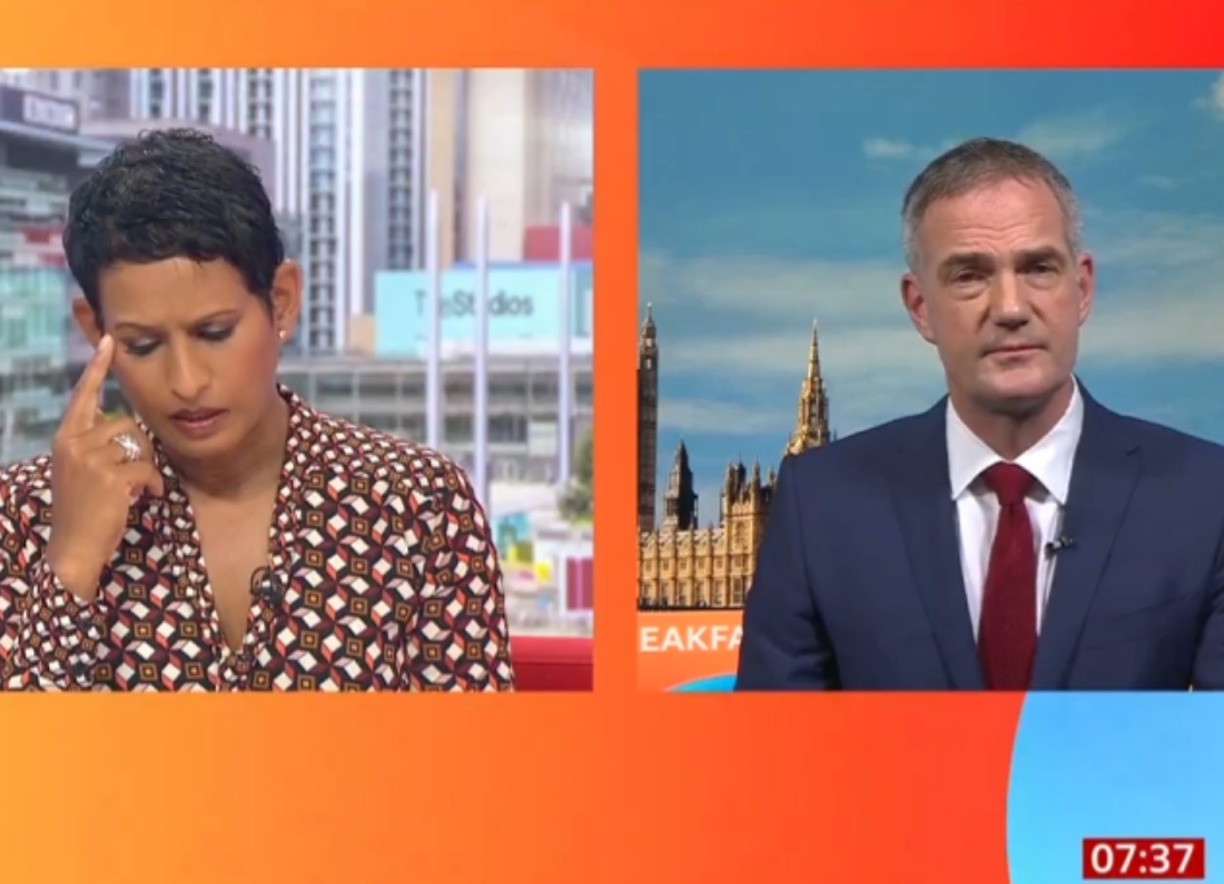 BBC Breakfast presenter Naga Munchetty listens with a sceptical expression during an interview with Business Secretary Peter Kyle, who appears remotely from Westminster while discussing the government's defence spending plans.