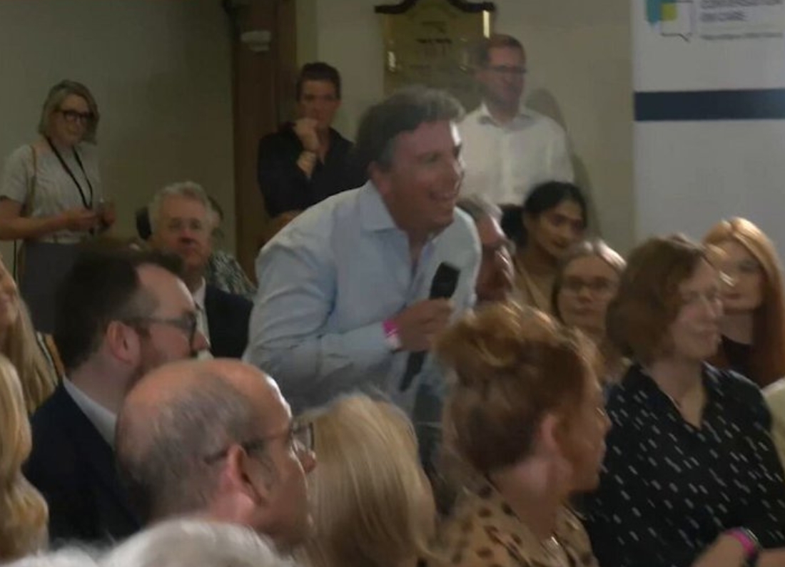 GB News political editor Christopher Hope stands with a microphone during Andy Burnham’s social care press conference.