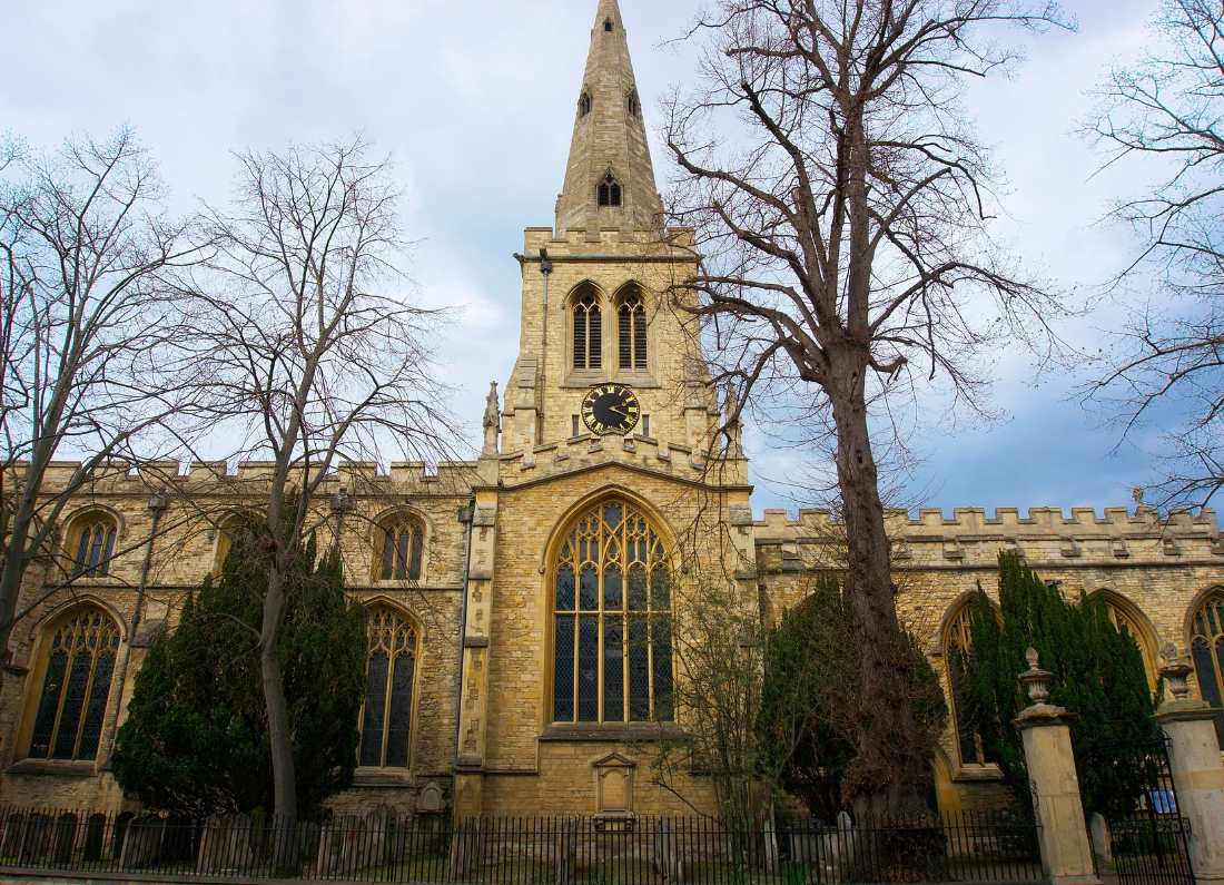Historic St Paul’s Church in Bedford, featuring its tall stone spire, clock tower and Gothic-style arched windows.