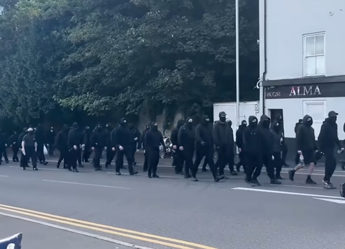 Masked protesters dressed in black marching through Dover during an anti-migrant demonstration